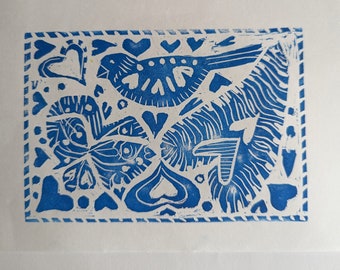 May include: Blue and white linocut print featuring a bird, hearts, and abstract floral designs. The print is framed by a blue and white border.