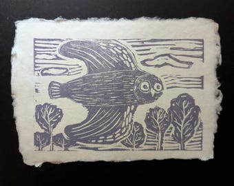 May include: A rectangular print on off-white textured paper with deckled edges. The artwork features a purple ink linocut illustration of an owl in flight above a landscape of stylized trees, with horizontal lines representing the sky.