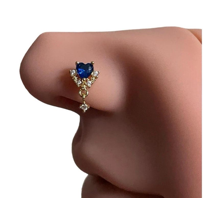 May include: A gold nose ring with a blue heart-shaped gemstone and clear crystal accents.