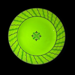 May include: A round, lime green plate with a black and green wavy border design. The center of the plate features a small, decorative cross-shaped design with black and green accents. The plate is set against a black background.