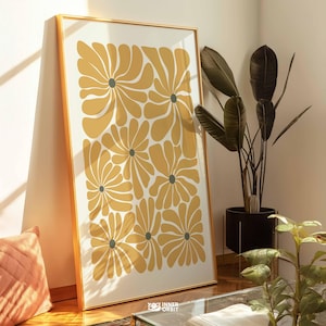 Può includere: Una stampa artistica incorniciata con un motivo floreale ripetuto in giallo e grigio. La stampa è in una cornice dorata e appoggiata a un muro. L'opera d'arte ha uno stile moderno e astratto. Adatta per l'arredamento.