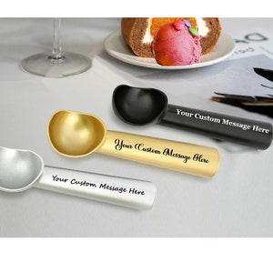 May include: Three ice cream scoops in silver, gold, and black with personalized messages. The scoops are on a white surface.  "Your Custom Message Here" is written on each scoop.