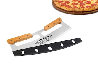 Könnte beinhalten: Ein schwarzer und silberner Pizzamesser mit einem Holzgriff. Das Messer hat eine gebogene Klinge mit vier Löchern und die Worte "Smith Family Pizzeria" sind in die Klinge graviert.