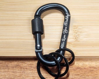 May include: Black carabiner keychain with three metal rings and the engraved text "We Love You Daddy!"