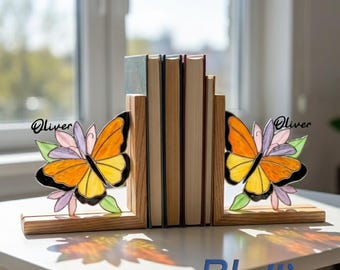 May include: A pair of wooden bookends featuring stained glass butterfly accents in orange, yellow, and purple. Each butterfly is attached to a light-toned wood base and displays the name Oliver in black script text on the upper wing.