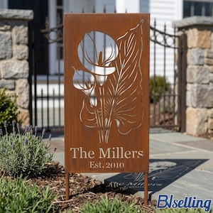 A wooden sign with a metal design featuring a flower and the text "The Millers Est. 2010" is displayed in a garden setting.