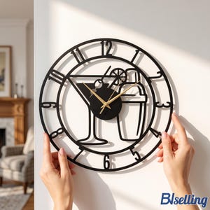 May include: A circular black metal wall clock featuring a cutout design of a martini glass with an olive and a cocktail shaker. The clock face has black numerals and thin gold-coloured hour, minute, and second hands centred on the design.