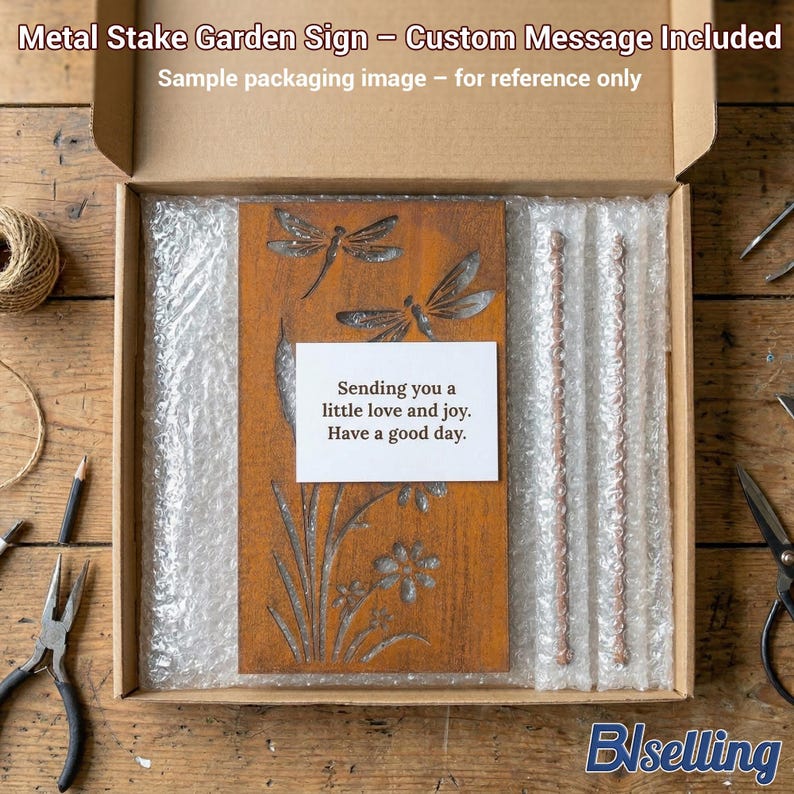 a wooden garden sign with a message, placed in a cardboard box with bubble wrap, and various crafting tools and materials are scattered around the box on a wooden surface.