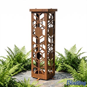 May include: A tall, rectangular, rusty brown metal garden pillar with geometric cut-out designs. The pillar has a square top and base, and is surrounded by green ferns. The pillar is likely used for decorative purposes in a garden or outdoor space.