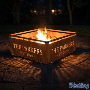 May include: A square metal fire pit with a rusted finish featuring cut-out text that reads THE PARKERS EST. 2026 on its sides. The fire pit is illuminated from within by bright orange flames, casting a warm glow on the surrounding ground surface.
