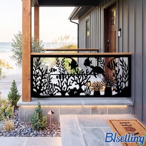 May include: A black metal railing panel featuring a laser-cut design of an underwater coral reef scene. The intricate pattern displays various fish, a sea turtle, and coral formations, installed as a decorative barrier on a porch overlooking the ocean.