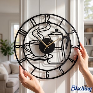 May include: A circular black metal wall clock featuring a cutout design of a coffee cup with steam and a coffee pot. The clock face has large black numerals from one to twelve and thin gold-coloured hour, minute, and second hands at the centre.