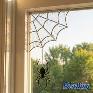 May include: A stained glass spider web corner piece with a textured clear glass finish and a dark metal spider hanging from a short chain. The web is designed to fit into the corner of a window frame, featuring a geometric pattern.