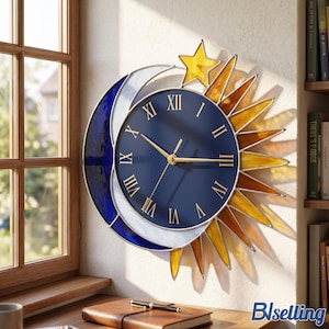 May include: A wall clock featuring a circular dark blue face with gold Roman numerals and gold hands. The clock is framed by a stained glass crescent moon in shades of blue and white, and a sunburst design with yellow and amber glass rays.