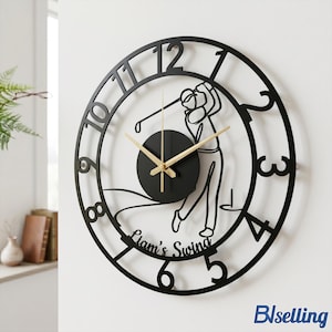 May include: Black metal golf-themed wall clock. The clock features a cutout design of a golfer mid-swing, with the words "Liam's Swing" below. The clock hands are light brown, and the numbers are in a modern font.