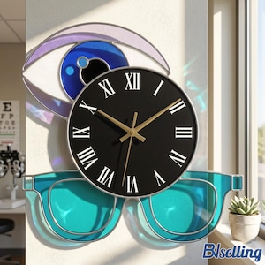 May include: A wall clock featuring a black circular face with gold hands and white Roman numerals. The clock is framed by a stylized eye shape with a blue iris at the top and a pair of teal-colored glasses at the bottom, all outlined in silver.