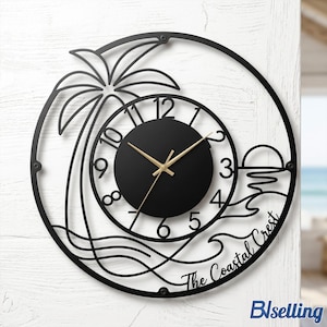 May include: Black metal wall clock featuring a palm tree, sunset, and ocean wave design. The clock face is black with gold hands and numbers. The text "The Coastal Crest" is written on the clock. The clock is mounted on a white surface.