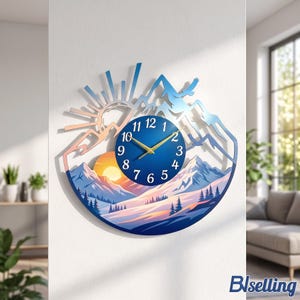 May include: A circular wall clock featuring a mountain landscape with a sunrise, pine trees, and a bird silhouette. The clock face is deep blue with white numerals and gold hands. The upper frame shows a stylized sun and mountain peaks.