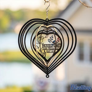 May include: A black heart-shaped wind spinner with concentric layers. The center features a cutout design of a rose, a bird on a branch, and the text "OLIVER & JAMES 40th Anniversary EST. 1975". It hangs from a silver metal hook and swivel.