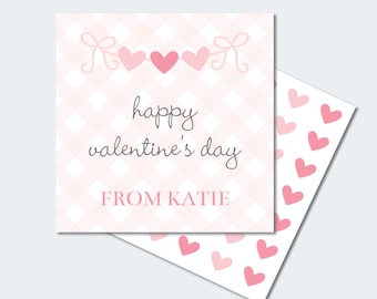 May include: Printable Valentine's Day card with a pink and white gingham pattern. The card features a string of pink hearts with a bow at each end. The text "happy valentine's day" and "FROM KATIE" is printed in black. The card is surrounded by a sheet of pink hearts.