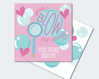 May include: A pink printable card with the text "you blow me away!" in purple and blue lettering. The card features a cartoon bubble wand with a blue and white bubble. The text "Your friend, Kortlyn" is at the bottom of the card.