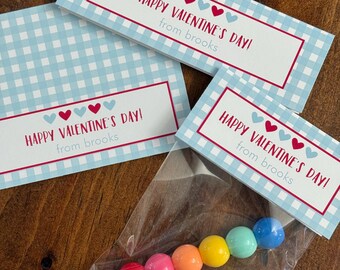 May include: Valentine's Day gift tags with a light blue gingham pattern and red borders. The tags read "HAPPY VALENTINE'S DAY! from brooks." A clear plastic bag contains colorful candies, including red, pink, orange, yellow, green, and blue.