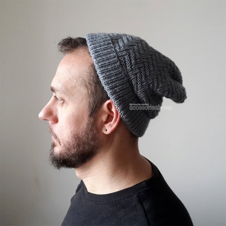 Puede incluir: Un gorro de punto gris con un patr&oacute;n texturizado. El gorro es holgado y tiene un borde doblado.