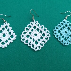 May include: Three pairs of crocheted earrings, two white and one light blue, with silver hooks.