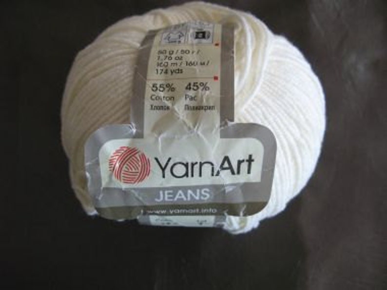 May include: A ball of white YarnArt Jeans yarn, a cotton and acrylic blend. The label reads "55% Cotton 45% Acrylic" and "100m/160m/174 yds".