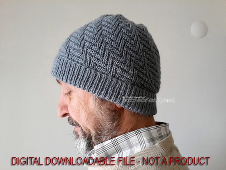 Puede incluir: Un gorro de punto gris con un patr&oacute;n de chevron. El gorro lo lleva puesto una persona con barba.