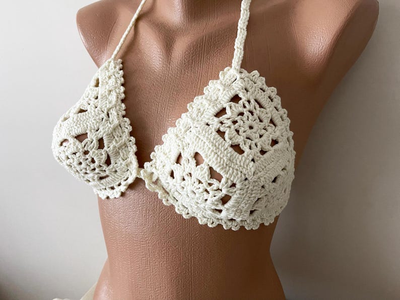 May include: A white crocheted bikini top with a delicate floral pattern.