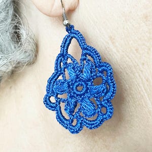 Peut inclure: Une paire de boucles d'oreilles en crochet bleu avec un motif floral.