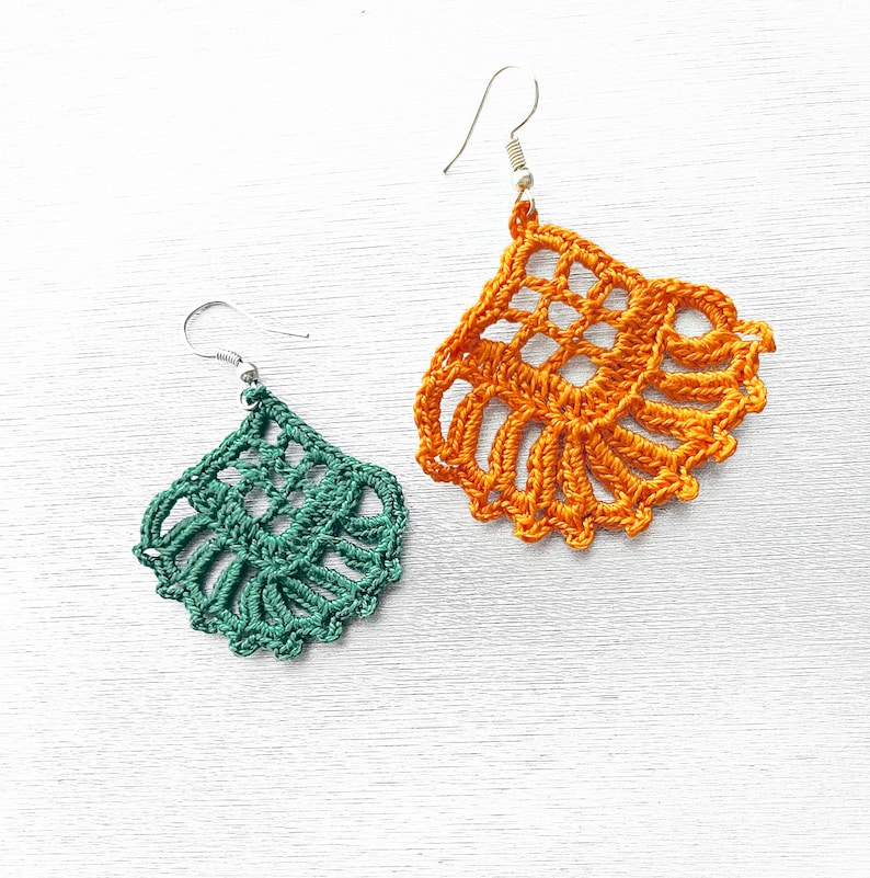 Puede incluir: Un par de pendientes de ganchillo, uno verde y otro naranja, con ganchos plateados. Los pendientes tienen forma de l&aacute;grima y un dise&ntilde;o delicado y de encaje.