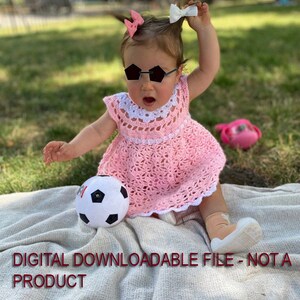 May include: A baby girl wearing a pink crocheted dress, black sunglasses, and a white bow in her hair. She is sitting on a white blanket with a soccer ball in front of her. The text "DIGITAL DOWNLOADABLE FILE - NOT A PRODUCT" is at the bottom of the image.