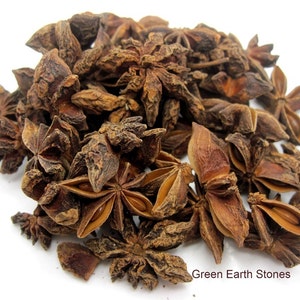 May include: A pile of dried star anise, a brown spice with a star shape, on a white background. Green Earth Stones is written in the bottom right corner of the image.