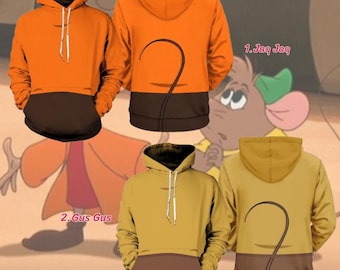 May include: Two hooded sweatshirts featuring long sleeves and a front pocket. The first hoodie is orange with a dark brown lower section and a curved line on the back. The second hoodie is mustard yellow with a dark brown lower section and a curved line on the back. Both include white drawstrings at the neck.