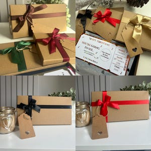 May include: Rectangular brown cardboard gift boxes tied with satin ribbons in various colours including red, green, black, and gold. Each box features a matching brown cardstock gift tag with a heart-shaped cutout. One box contains a printed ticket.