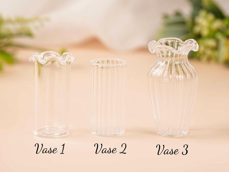 May include: Three clear glass vases with distinct designs. Vase 1 has a ruffled top, Vase 2 is cylindrical with vertical lines, and Vase 3 has a flared shape with a ruffled top. The text "Vase 1", "Vase 2", and "Vase 3" are below each vase.