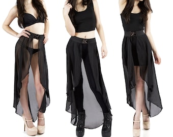 Puede incluir: Tres mujeres con atuendos negros con faldas negras transparentes. Las faldas son de capas y tienen un dobladillo alto-bajo. Las mujeres llevan blusas negras y leggings negros. Las faldas tienen un cinturón negro con hebilla.