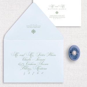 Könnte beinhalten: Ein hellblauer Umschlag mit einem weißen Umschlag im Inneren. Die Adresse auf dem äußeren Umschlag lautet auf Mr. and Mrs. Victor Blaire, Charlie und Sammi, 6123 Graham Avenue, Billings, Montana, 48760. Die Adresse auf dem inneren Umschlag lautet auf Mr. and Mrs. Matthew Harris, 12995 Green Acres Way, New Orleans, Louisiana.