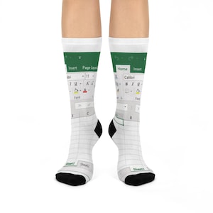 May include: White crew socks featuring a printed design of a spreadsheet interface. The design includes green menu bars with text like "Insert" and "Page Layout", and a grid-like spreadsheet with "Sheet1" and "Sheet2" labels. The socks have black heels and toes.