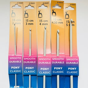 May include: Five packages of Pony brand crochet hooks, each with a different size hook. The hooks are 15 cm long and range in size from 2 mm to 5 mm. The packages are yellow and blue with the text "Smooth Durable Pony Classic" and "Create beauty with Pony".