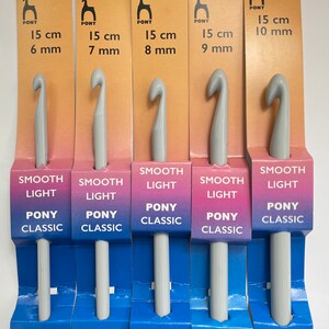 May include: Five gray crochet hooks with the brand name "Pony Classic" and the text "Smooth Light" printed on the packaging. The hooks are labeled with sizes ranging from 6 mm to 10 mm.