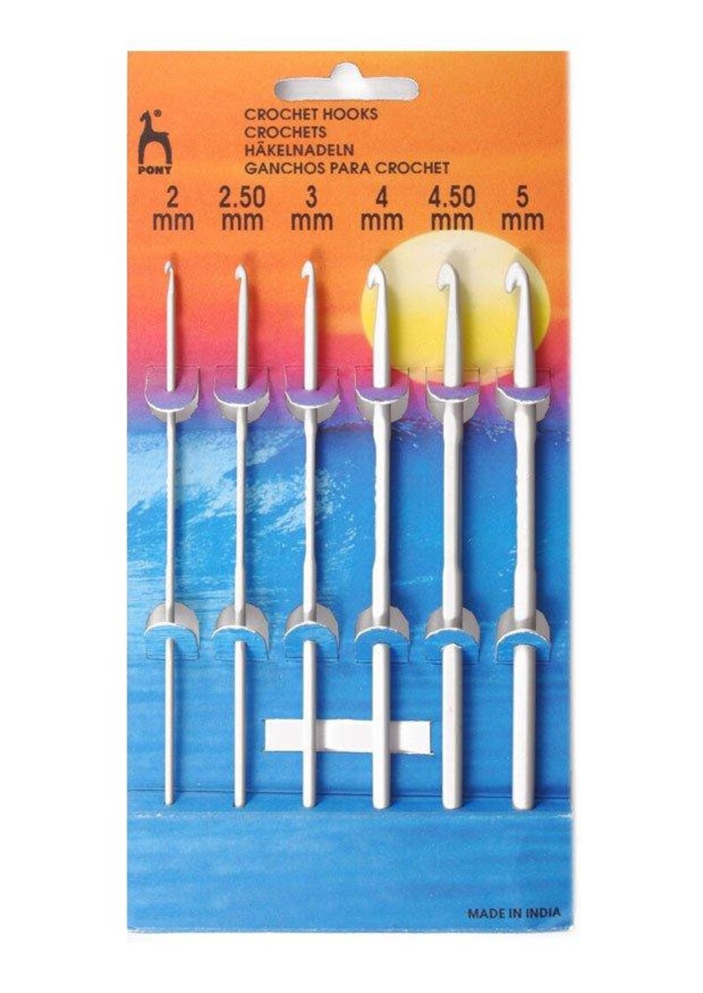 May include: A set of six white crochet hooks in a plastic package. The hooks are labeled with their sizes in millimeters: 2 mm, 2.50 mm, 3 mm, 4 mm, 4.50 mm, and 5 mm. The package is orange and blue with the text "CROCHET HOOKS, CROCHETS, H&Auml;KELNADELN, GANCHOS PARA CROCHET, MADE IN INDIA".