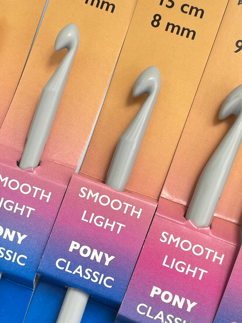 May include: A set of four gray crochet hooks with the text "Smooth Light Pony Classic" on the packaging. The hooks are labeled with sizes 8 mm, 9 mm, 10 mm, and 12 mm.