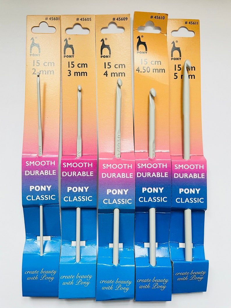May include: Five packages of Pony brand crochet hooks, each with a different size hook. The hooks are 15 cm long and range in size from 2 mm to 5 mm. The packages are yellow and blue with the text "Smooth Durable Pony Classic" and "Create beauty with Pony".