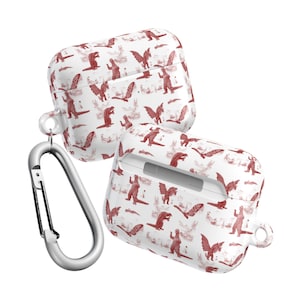 May include: Two white AirPod cases with a repeating pattern of red monster illustrations. The cases are shown with a silver carabiner clip. The cases are designed to protect and carry wireless earbuds.