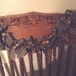 May include: A black and white checkered fabric garland draped over a wooden chair back.