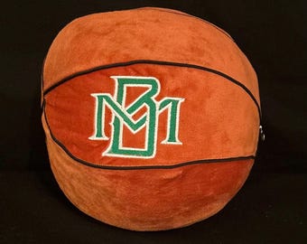 May include: Orange and brown plush basketball with a black stitched seam and a green and white embroidered "BM" logo.