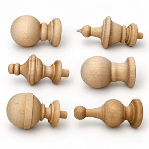 Puede incluir: Una colección de seis remates de madera de color claro sin acabado en varias formas, incluyendo diseños esféricos, puntiagudos y redondeados. Cada pieza presenta una textura de veta de madera natural lisa y un extremo de espiga.